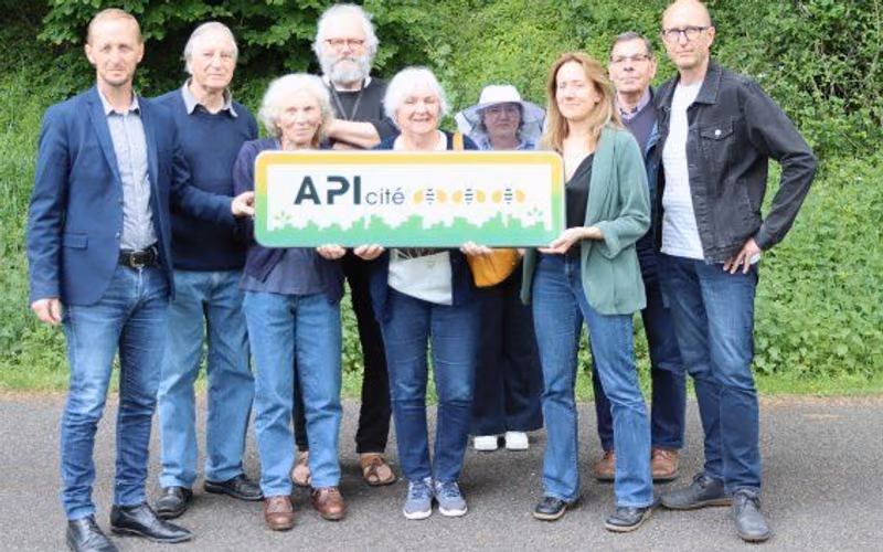 Élus de Montrollet, membres du collectif et de L’Arbre et l’Abeille posent avec le panneau API Cité devant les ruches de la commune (photo Gaëlle Pinaud, L’Avenir Le Confolentais)