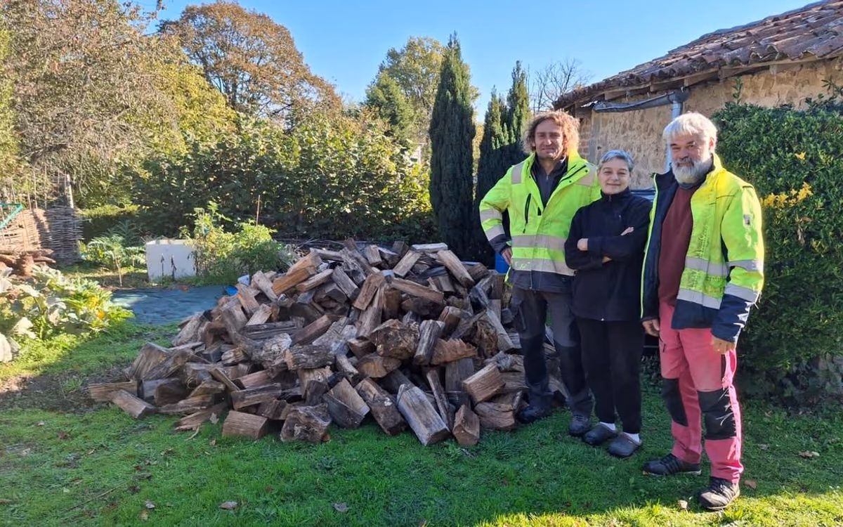 Les deux agents communaux lors de la livraison de bois chez une Monteirollaise bénéficiaire de l’opération (photo Charente Libre)