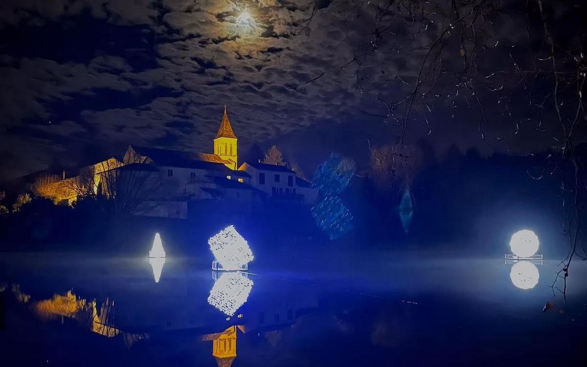 L’église Saint-Sulpice sous la lune, les structures lumineuses et leurs reflets sur l’étang communal, la nuit (photo Benoît Savy, Charente Libre)
